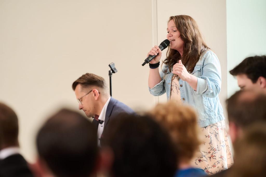 Sabine Ockel singend mit Mikrofon, vor ihr Dirk Ockel